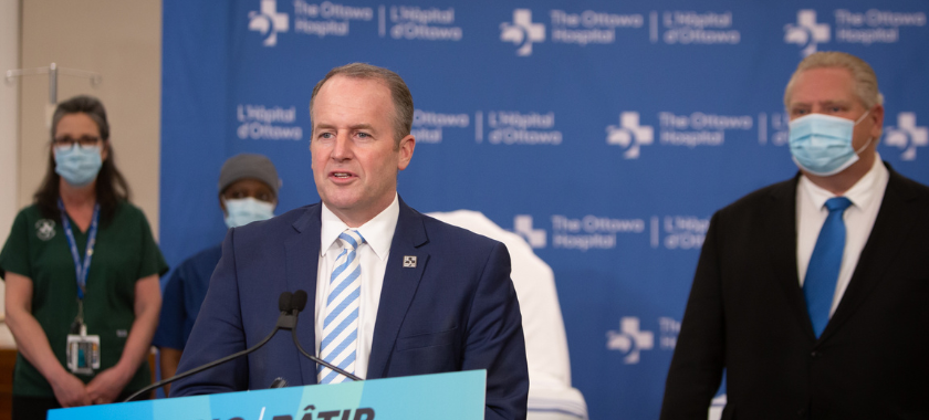 The Ottawa Hospital CEO Cameron Love stands at a podium with premier Doug Ford