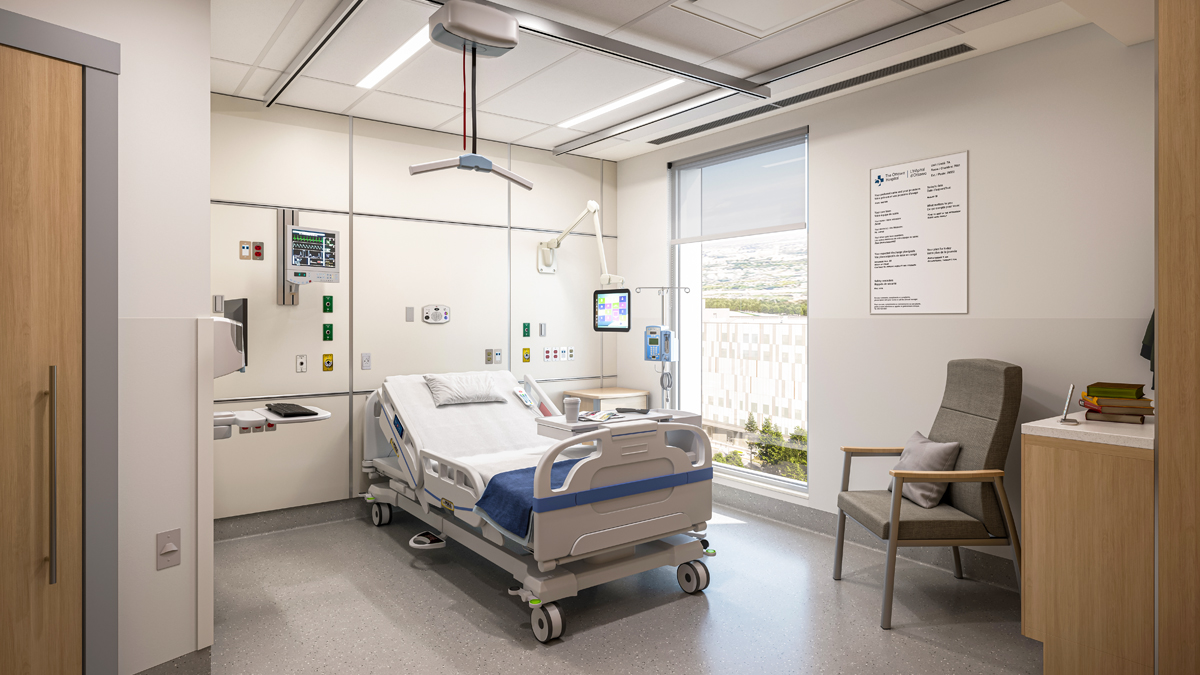 Représentation artistique de l’intérieur d’une chambre d’hôpital du nouveau campus de L’Hôpital d’Ottawa. Un lit de patient vide et divers équipements hospitaliers se trouvent au milieu de la chambre. Une porte menant à la salle de bain se trouve à gauche, et une grande fenêtre à droite du lit offre une vue dégagée sur l’extérieur. Il y a une chaise à côté d’un petit comptoir avec des livres à l’extrême droite.