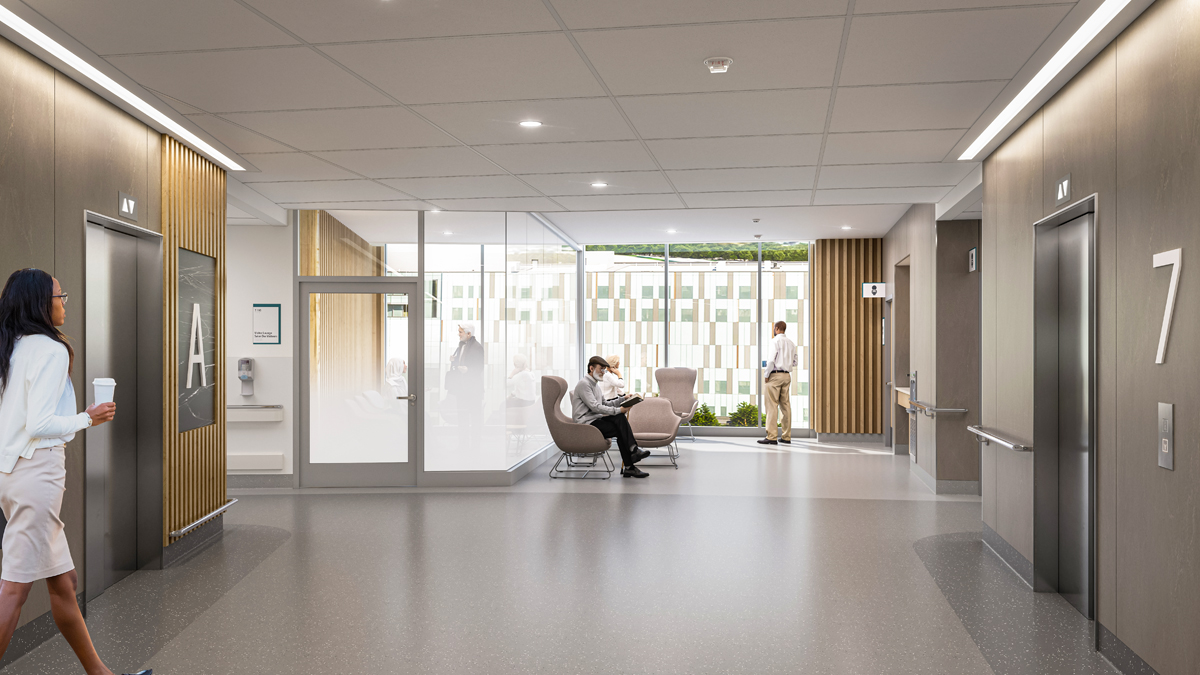  artist rendering oAnf a hallway inside a new hospital. The hall runs up the middle from the foreground to the background. Elevators are on either side of the hallways at left and right. In the background, there are chairs and large windows showing a clear view of the outdoors. On the left side of the background, a small room has glass walls which are gradually frosted on the lower half. People are standing and seated in various locations throughout the scene.